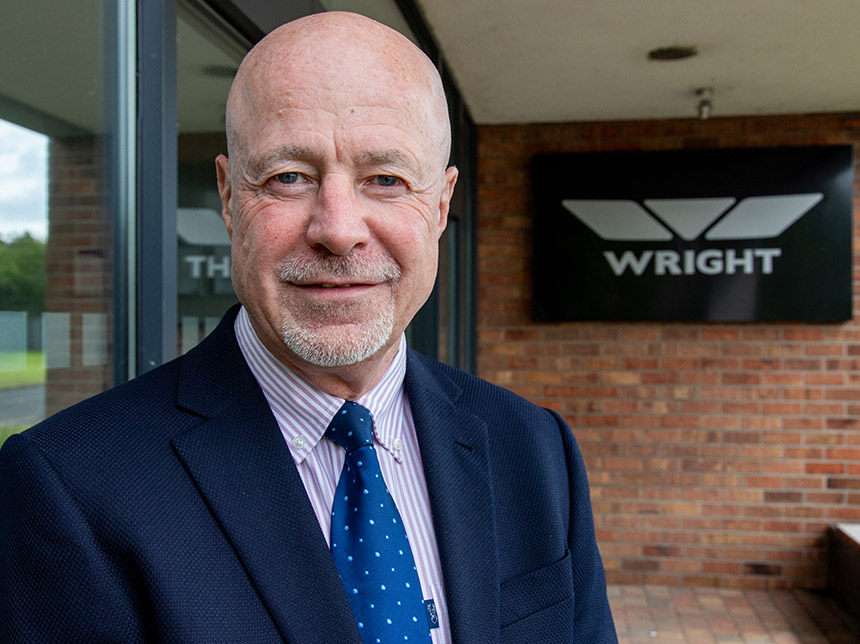 man standing in front of wrightbus sign