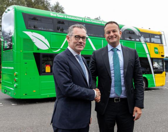 Taoiseach Leo Varadkar and Jean-Marc Gales shaking hands in front of a green and yellow double deck bus
