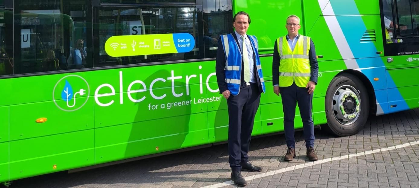 men standing in front of a green double deck bus