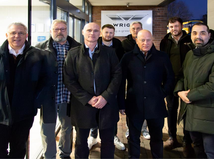 Eine Gruppe Männer steht vor einer Fabrik