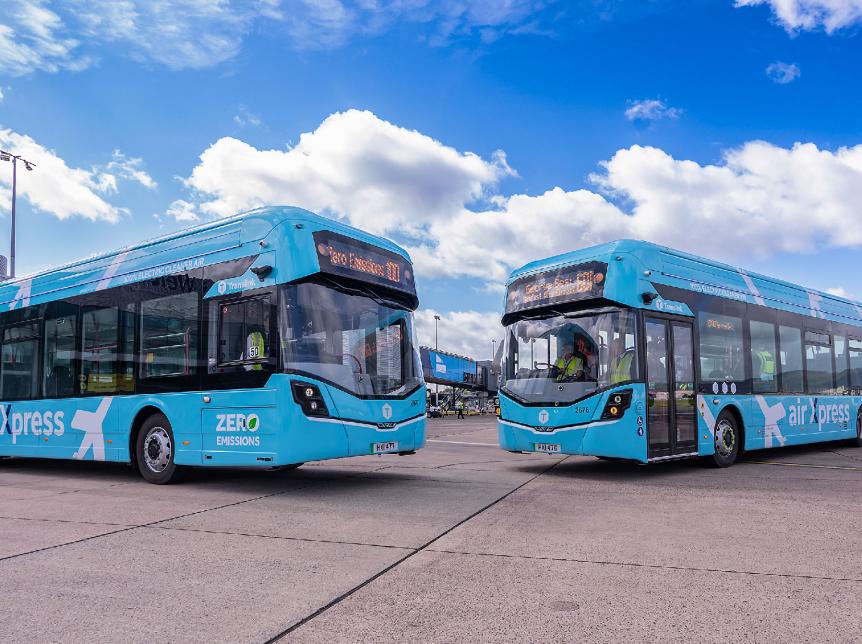 two airport buses parked on the runway on a sunny day