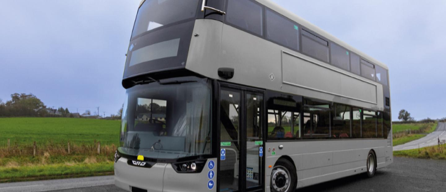 grey double deck diesel bus parked on the side of the road in the countryside