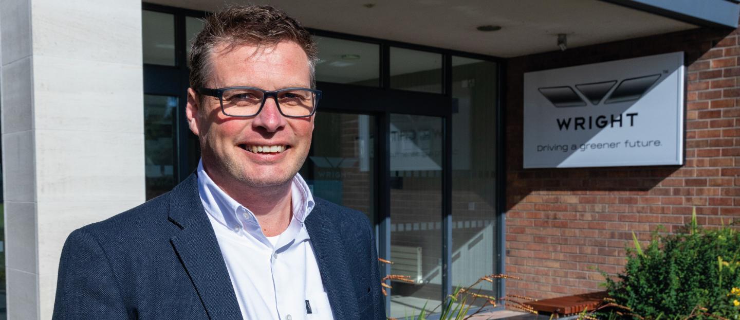 James Hamill smiling in front of the wrightbus main entrance