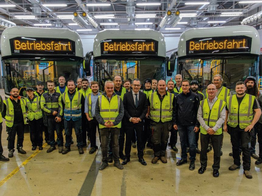 Jean-Marc Gales with representatives from RVK and Wrightbus team standing in front of three RVK buses in the Ballymena factory