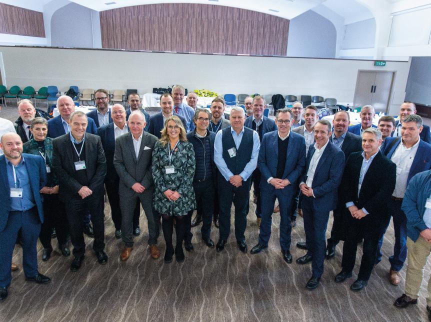 group of suppliers and Wrightbus team at the recent Supplier Event. The group are all standing in rows smiling at the camera