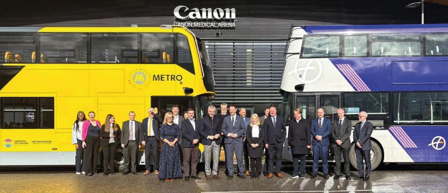 line up of senior leaders from Wrightbus and government and local authority figureheads at the UK’s first bus manufacturing panel. The group are standing in front of 2 double deck buses 