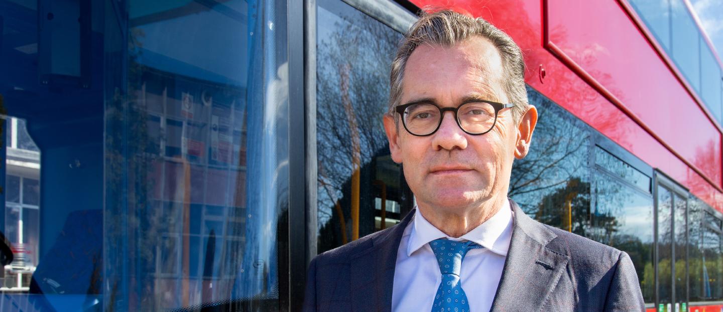 Jean-Marc Gales, Wrightbus CEO standing in front of of a red bus