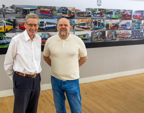 Christian Reynolds and Paul Savage with Wrightbus 80th wall photo montage